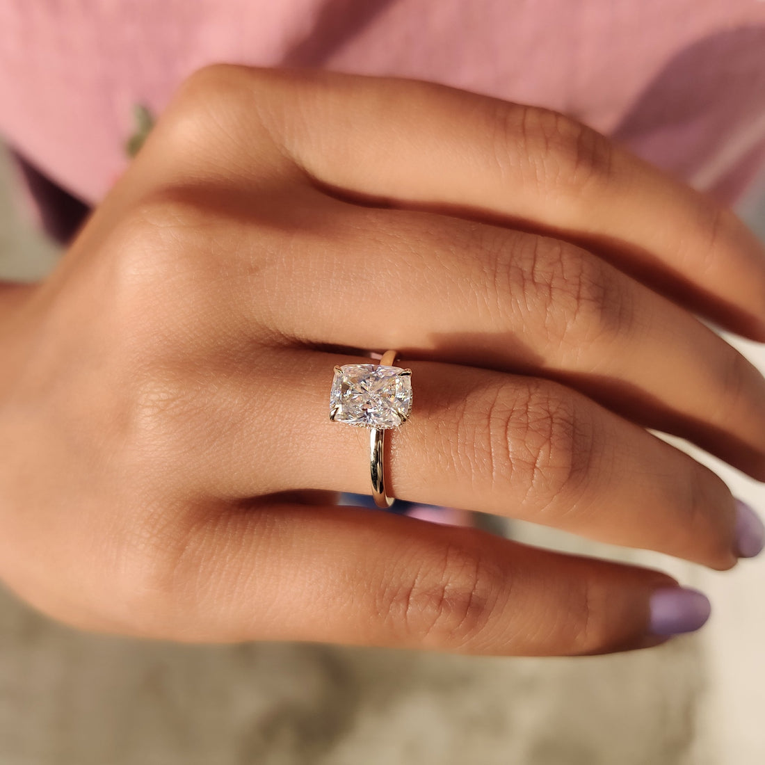 Elongated cushion cut moissanite hidden halo engagement ring on a plain yellow gold band