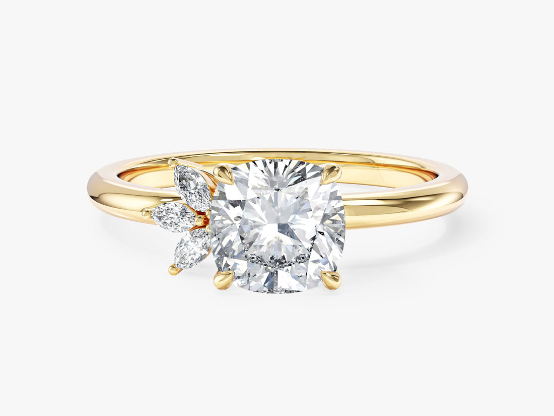 Cushion cut moissanite engagement ring with a cluster of three marquise stones on one side in 14K yellow gold, front view
