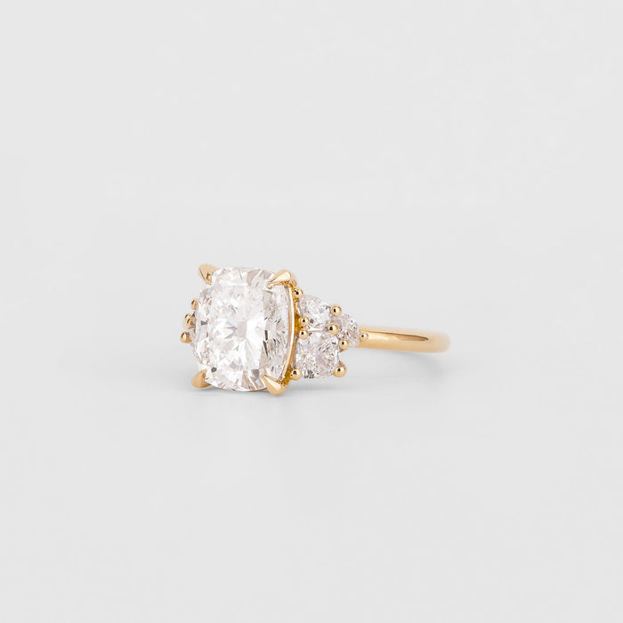 Cushion cut moissanite engagement ring with pear cluster shoulders in yellow gold, view 2