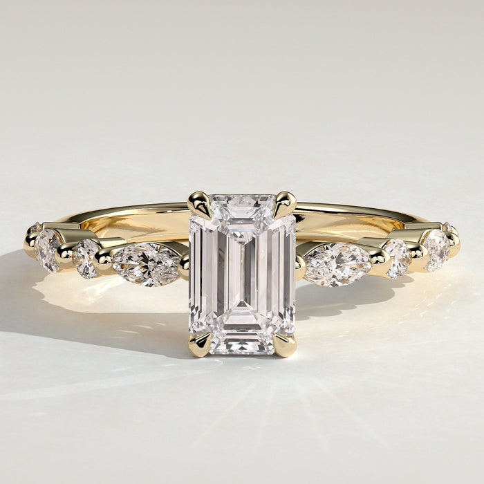 Emerald cut moissanite engagement ring with alternating marquise and round accents in yellow gold