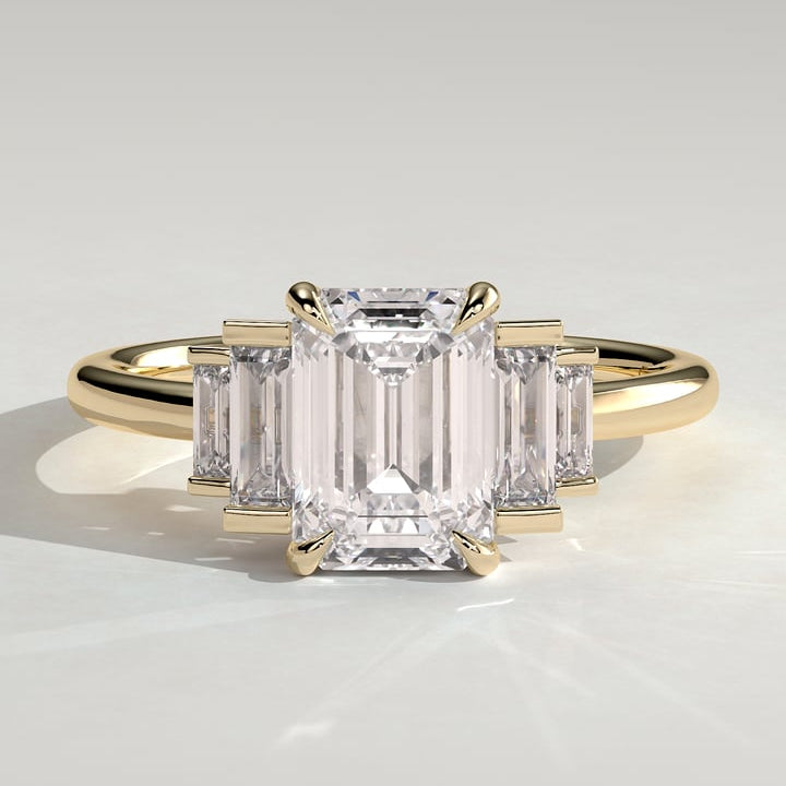 Emerald cut moissanite bar set baguette three stone engagement ring in yellow gold