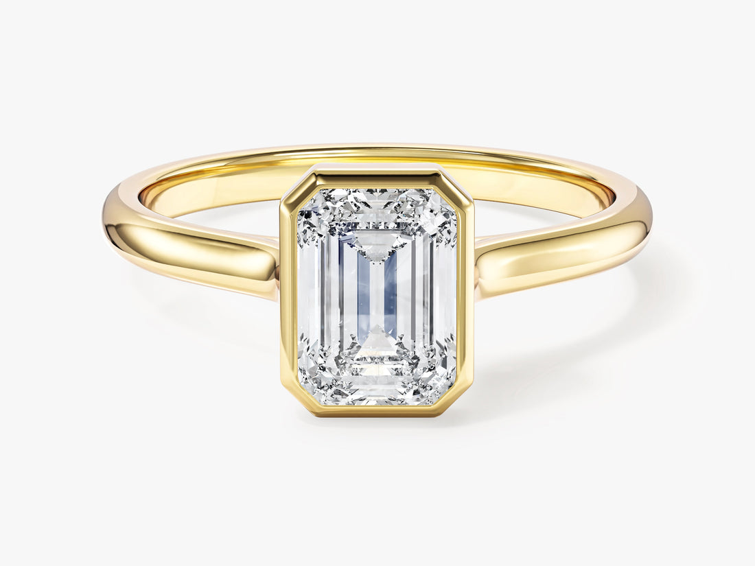 Dainty emerald moissanite full bezel engagement ring on a slim band in 14K yellow gold, front view