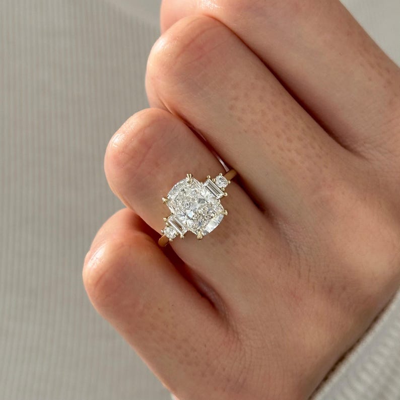 Elongated cushion moissanite cluster engagement ring with baguette and round side stones in yellow gold