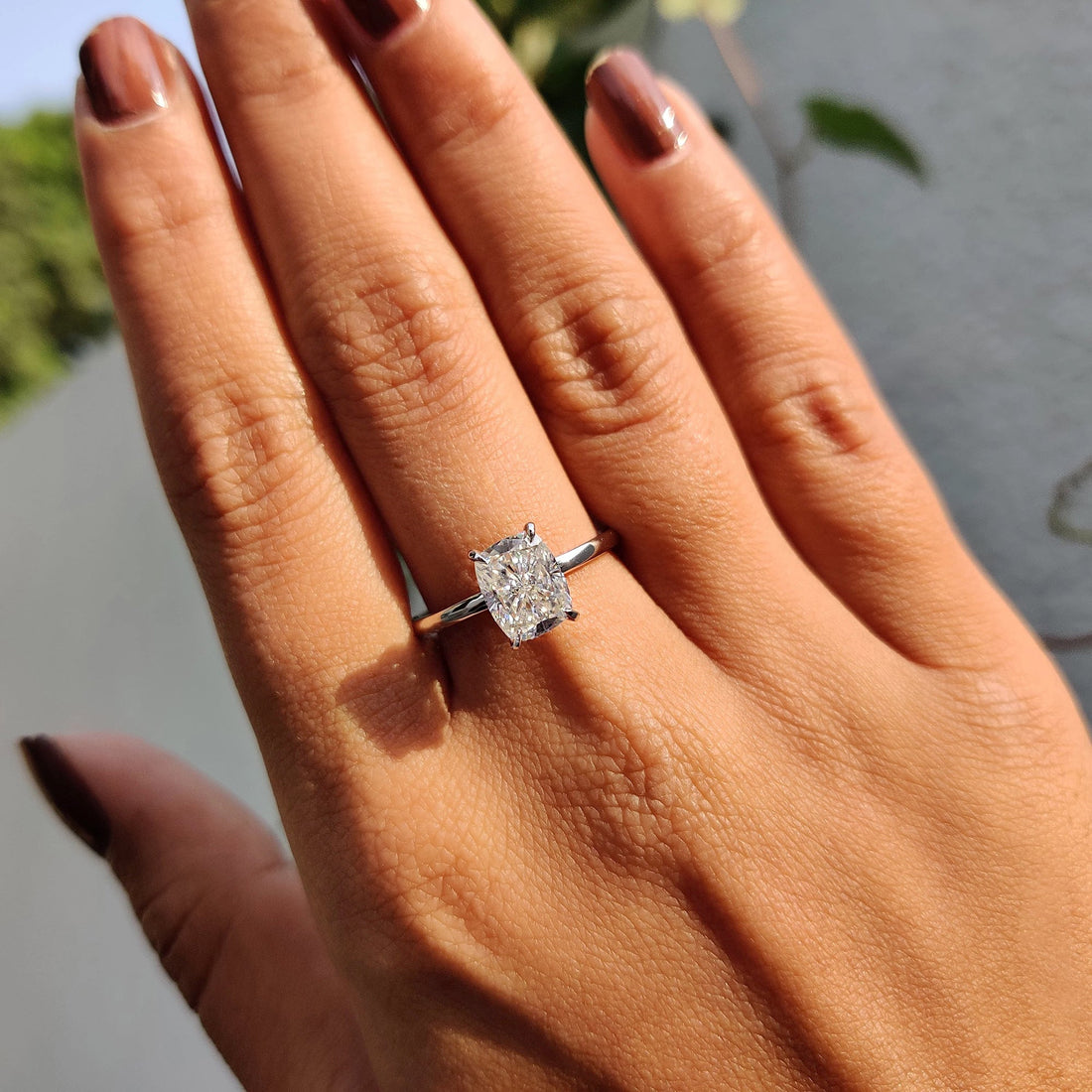 Elongated cushion cut moissanite cathedral solitaire engagement ring on a plain white gold band