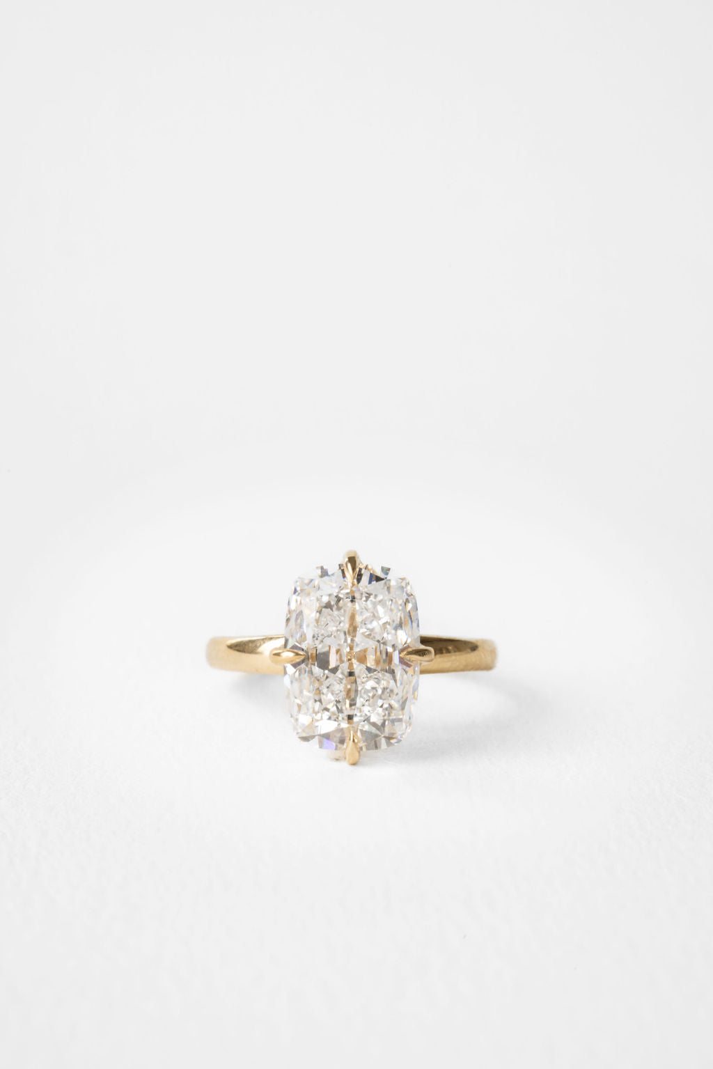 Large elongated cushion moissanite solitaire engagement ring on a hammered yellow gold band