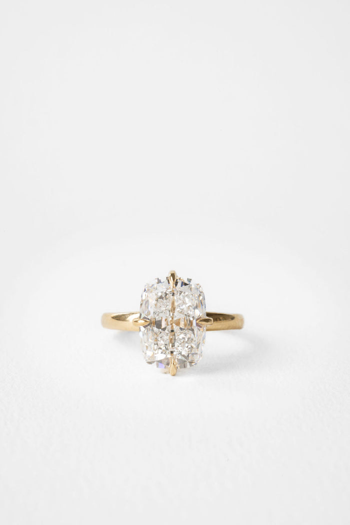 Large elongated cushion moissanite solitaire engagement ring on a hammered yellow gold band
