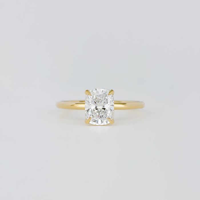 Elongated cushion moissanite four claw solitaire engagement ring on a plain yellow gold band