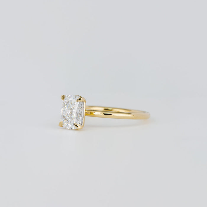 Elongated cushion moissanite four claw solitaire engagement ring on a plain yellow gold band, view 2