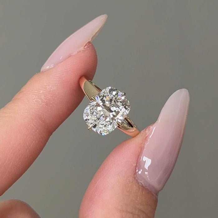 Elongated cushion moissanite hidden halo engagement ring on a tapered yellow gold band