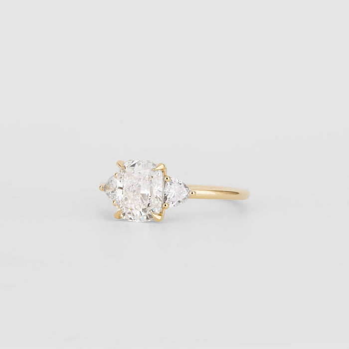 Elongated cushion moissanite three stone engagement ring with trillion side stones in yellow gold, view 2