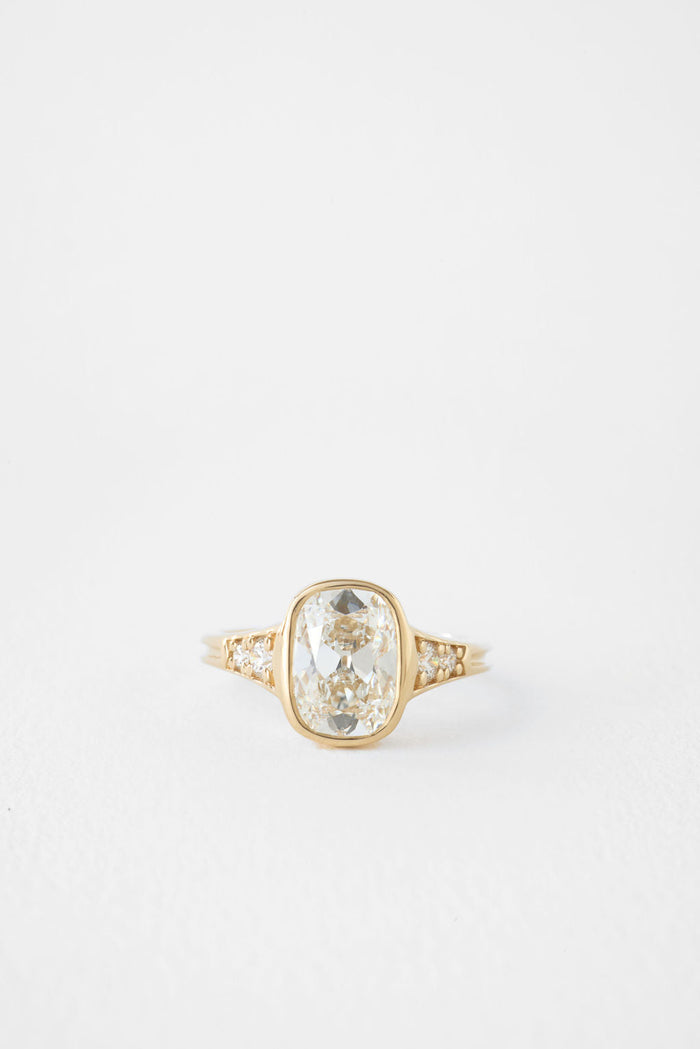 Antique elongated cushion moissanite bezel engagement ring with pave shoulders in yellow gold