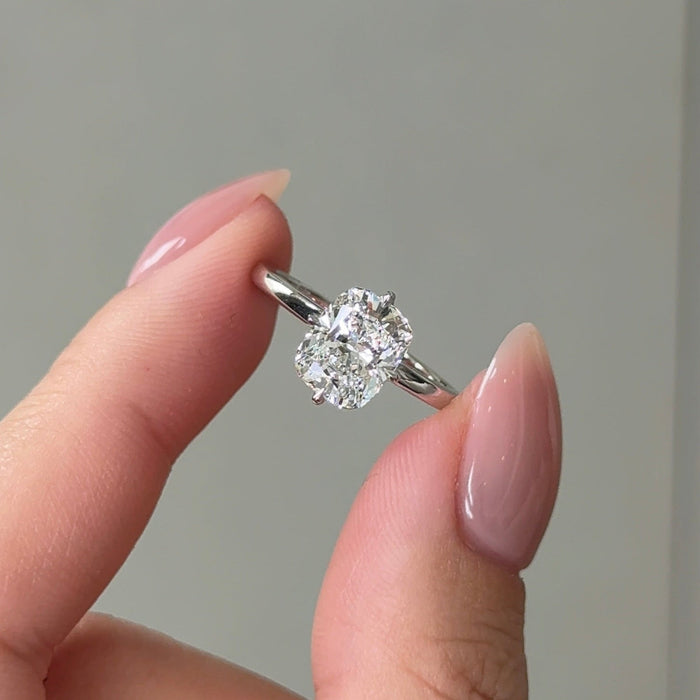Elongated cushion moissanite hidden halo engagement ring on a fine round white gold band