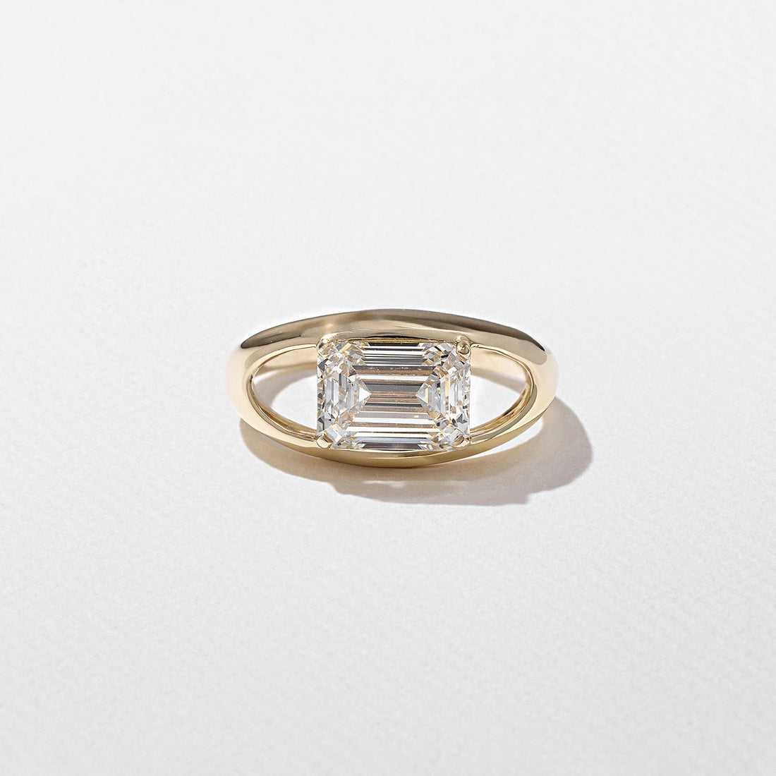 East west emerald cut moissanite floating split shank engagement ring in yellow gold
