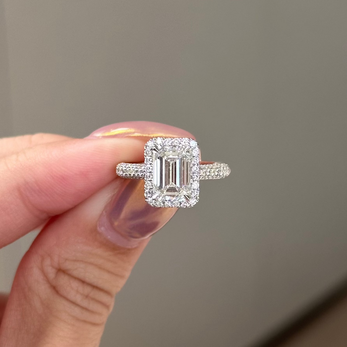 Emerald cut moissanite halo engagement ring on a three row pave white gold band