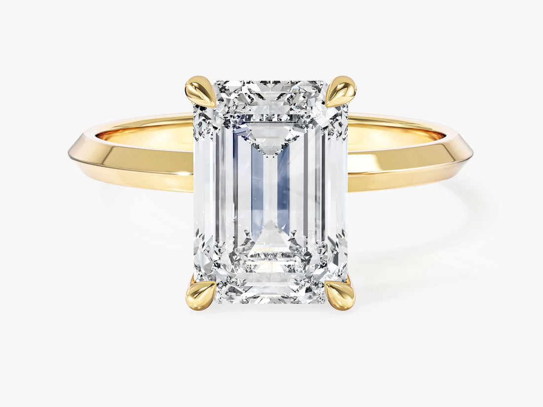 High set emerald cut lab grown diamond solitaire with knife edge band in yellow gold, front view