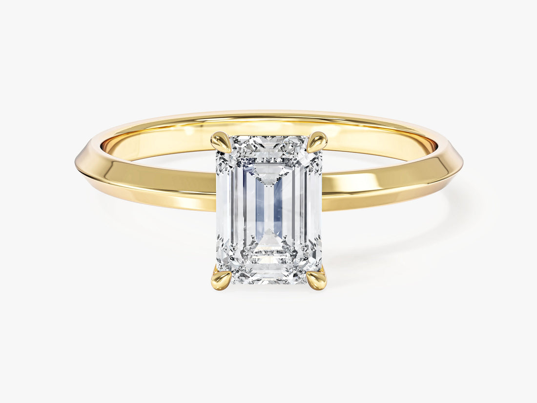 Minimalist emerald cut lab grown diamond solitaire with tapered knife edge shank in yellow gold, front view