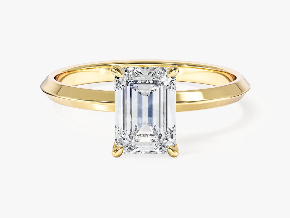 Emerald moissanite four claw engagement ring on a knife edge band in 14K yellow gold, front view