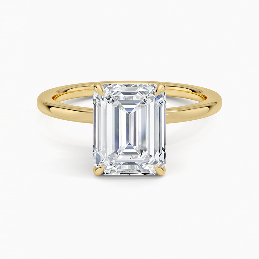 Emerald cut moissanite secret halo solitaire ring with slim band in yellow gold, top view
