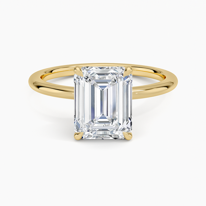 Classic emerald cut moissanite four prong solitaire engagement ring in yellow gold, top view