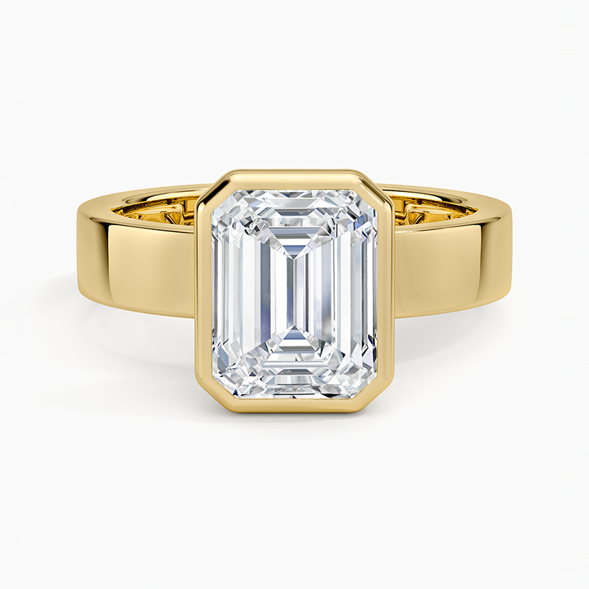 Full bezel emerald cut moissanite engagement ring on a wide flat yellow gold band, top view