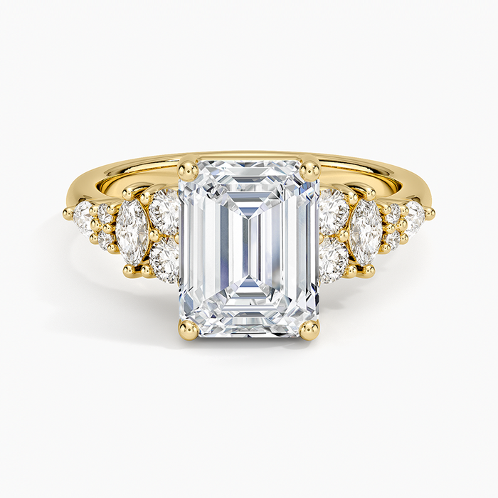 Emerald cut moissanite ring with marquise and round cluster shoulders in yellow gold, top view