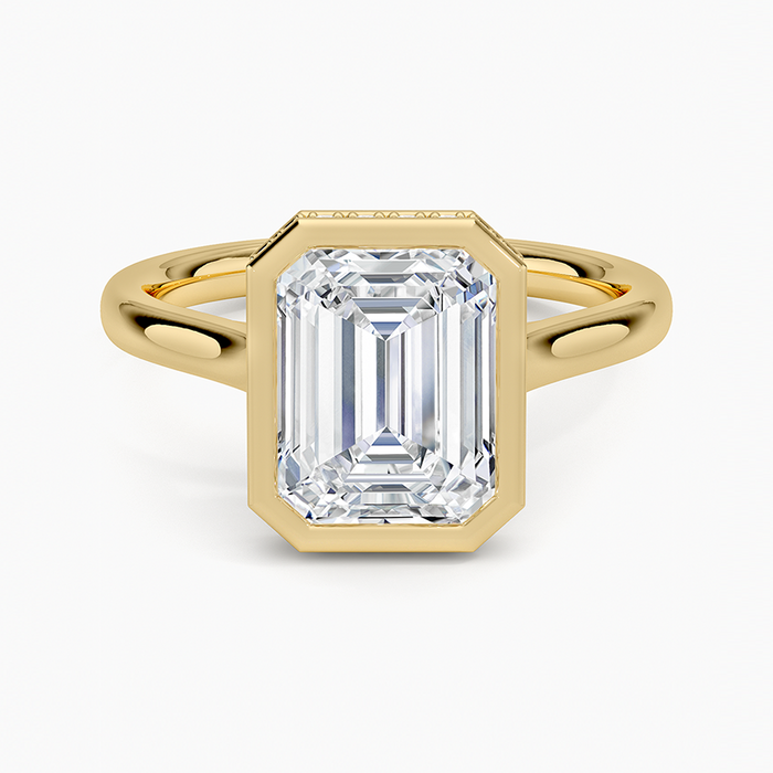 Bezel set emerald cut moissanite ring with hidden halo and milgrain in yellow gold, top view