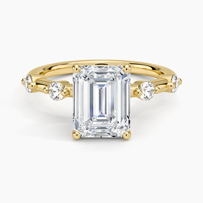 Emerald cut moissanite ring with spaced station accents in yellow gold, top view