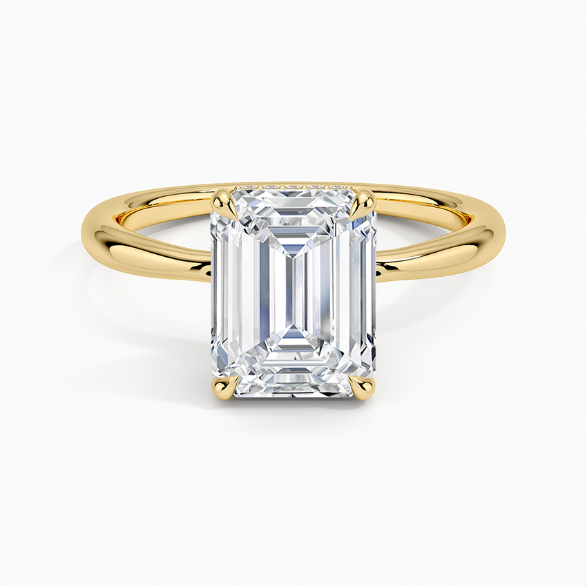 Emerald cut moissanite hidden halo solitaire on a plain yellow gold band, top view