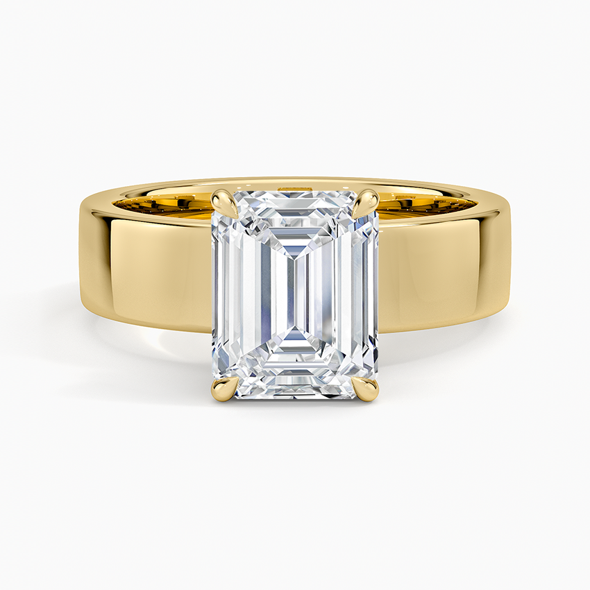 Emerald cut moissanite hidden halo ring on a wide polished band in yellow gold, top view