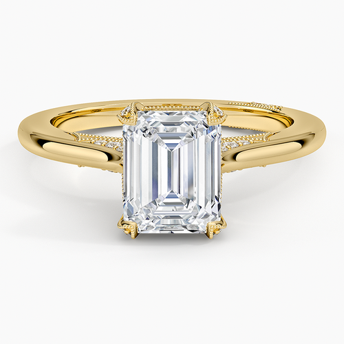 Emerald cut moissanite with a milgrain edged pave arch in yellow gold, top view