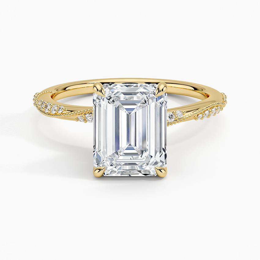 Emerald cut moissanite on a milgrain pave crossover twist band in yellow gold, top view
