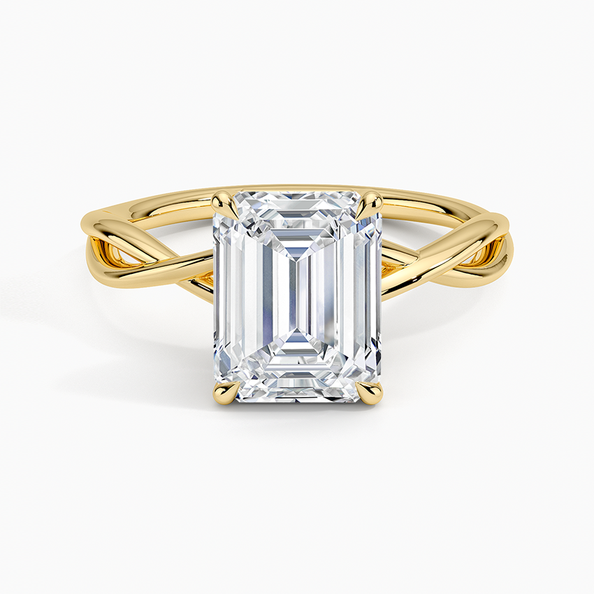 Emerald cut moissanite on an open crossover loop band in yellow gold, top view