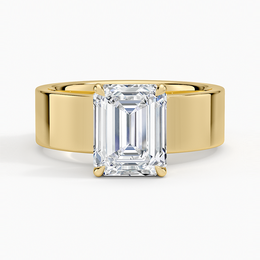 Emerald cut moissanite on a wide flat cigar band in yellow gold, top view