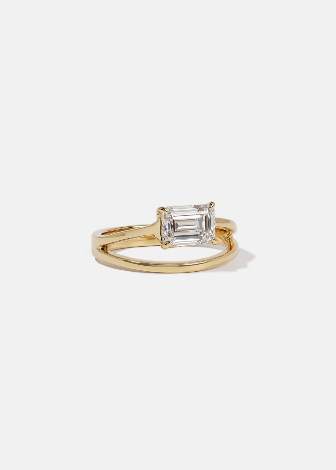 Emerald cut moissanite offset split shank solitaire engagement ring in yellow gold