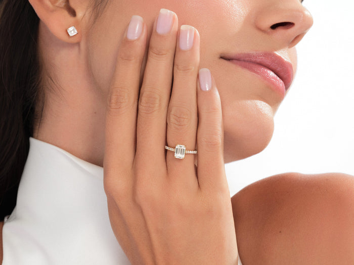 Emerald cut lab grown diamond pave ring in rose gold worn with the hand at the cheek