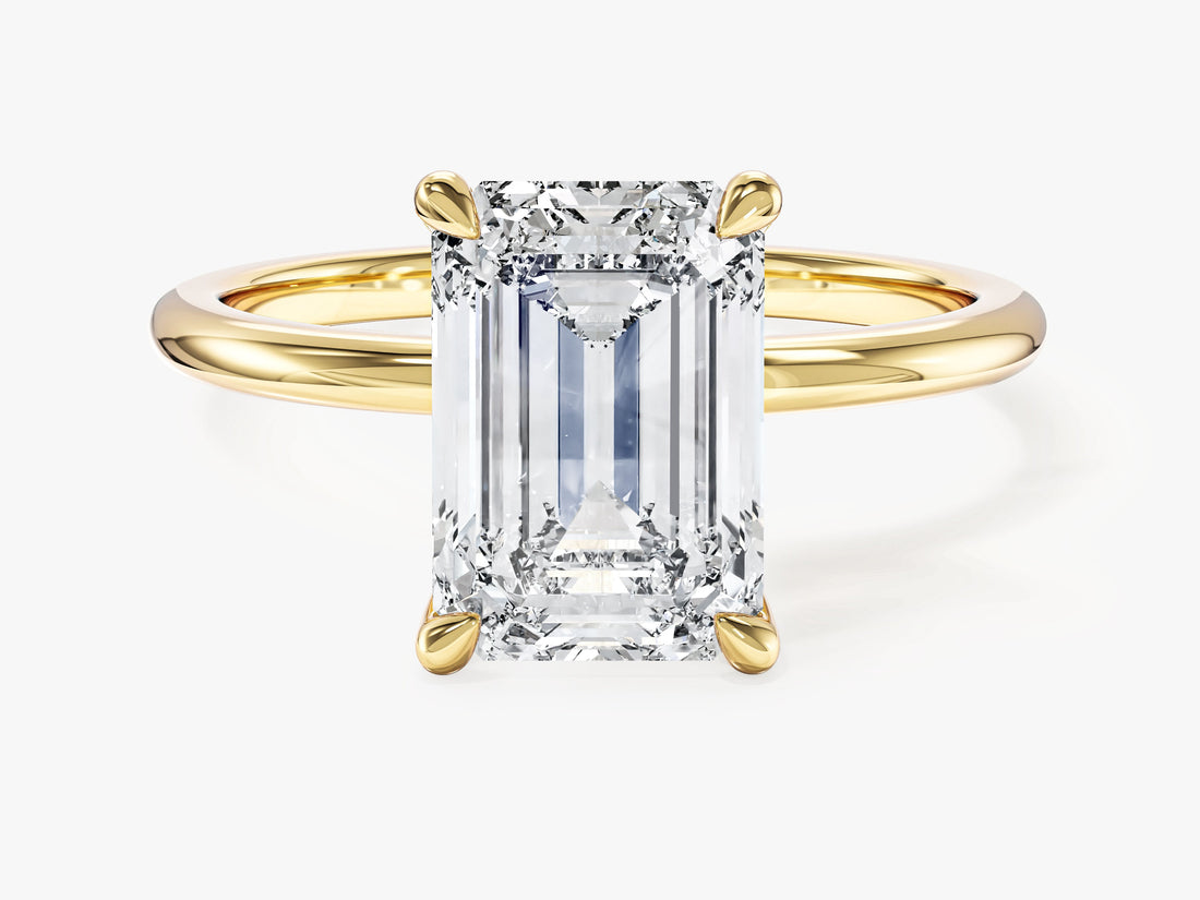 Emerald cut moissanite solitaire engagement ring with four claw setting in yellow gold, front view