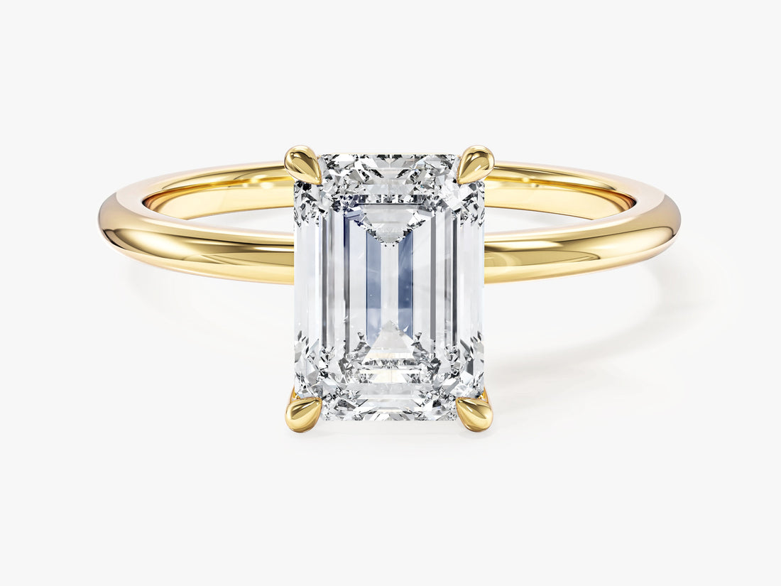 Classic emerald cut moissanite solitaire engagement ring on a plain yellow gold band, front view