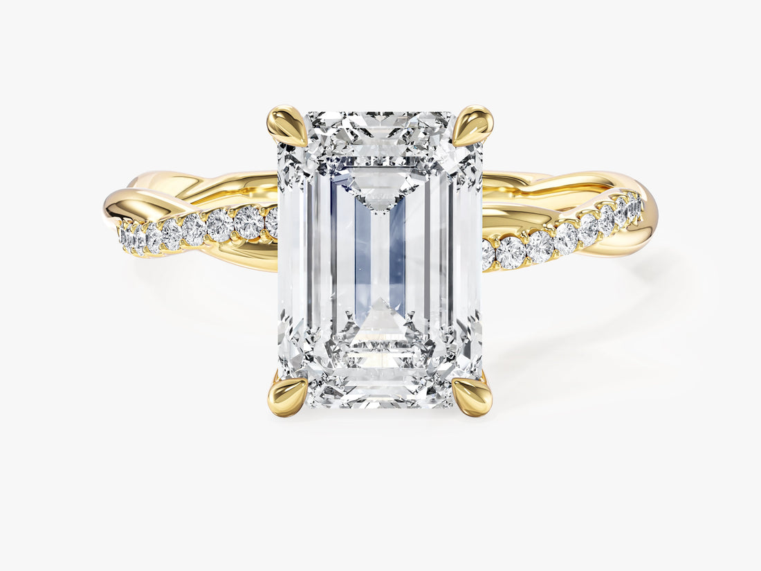 Large emerald cut moissanite twist engagement ring with pave strand in yellow gold, front view