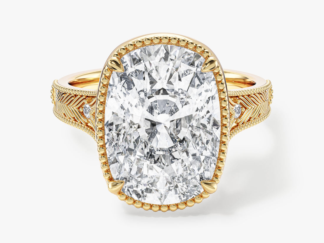 Elongated cushion moissanite vintage engagement ring with milgrain frame and engraved band in yellow gold, front view