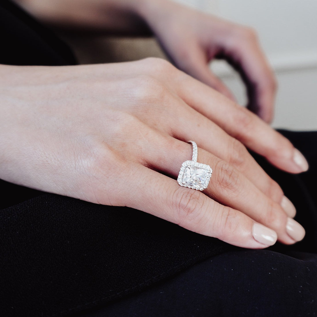 East west radiant cut moissanite halo engagement ring on a pave band in white gold