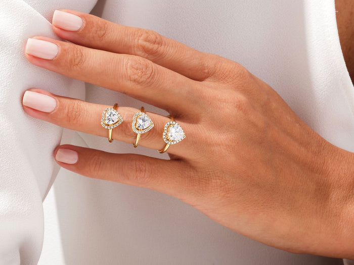 Three heart halo lab grown diamond rings worn together on one hand for size comparison