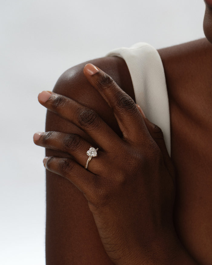 Heart cut lab grown diamond braided ring worn on a hand resting on the shoulder