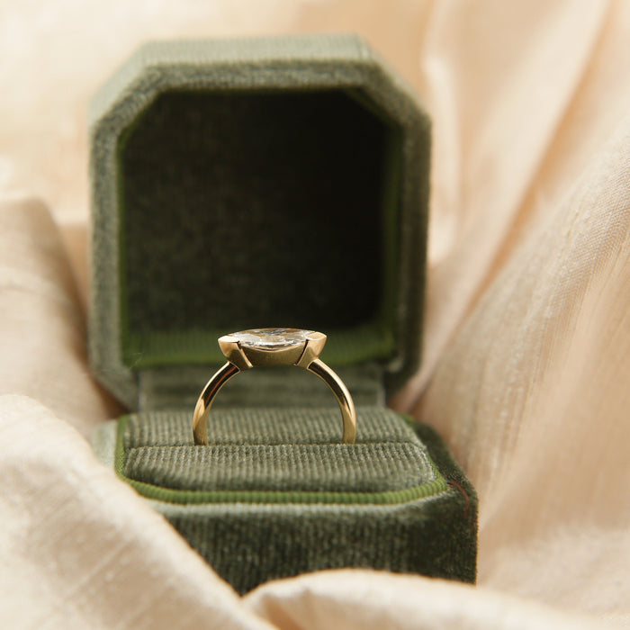 East west marquise moissanite angular bezel engagement ring on a fine yellow gold band, view 2