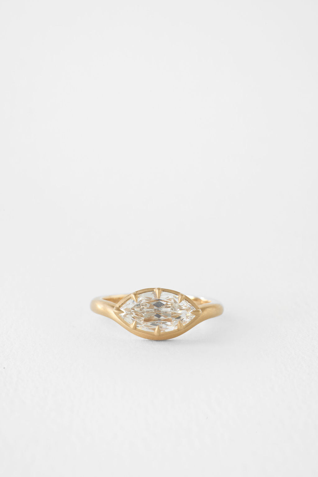 East west marquise moissanite brushed gold bezel engagement ring in yellow gold