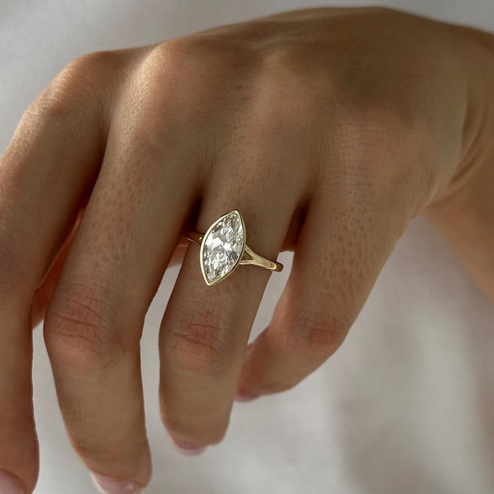 Marquise cut moissanite bezel set solitaire engagement ring in yellow gold, view 2