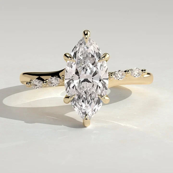 Marquise moissanite engagement ring on a curved band with graduated accents in yellow gold