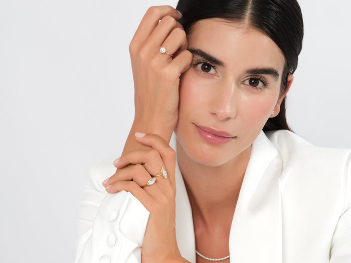 East west marquise lab grown diamond ring worn on the hand at the face with a white blazer