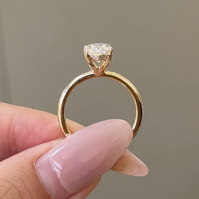 Marquise cut moissanite hidden halo engagement ring on a plain yellow gold band, view 2