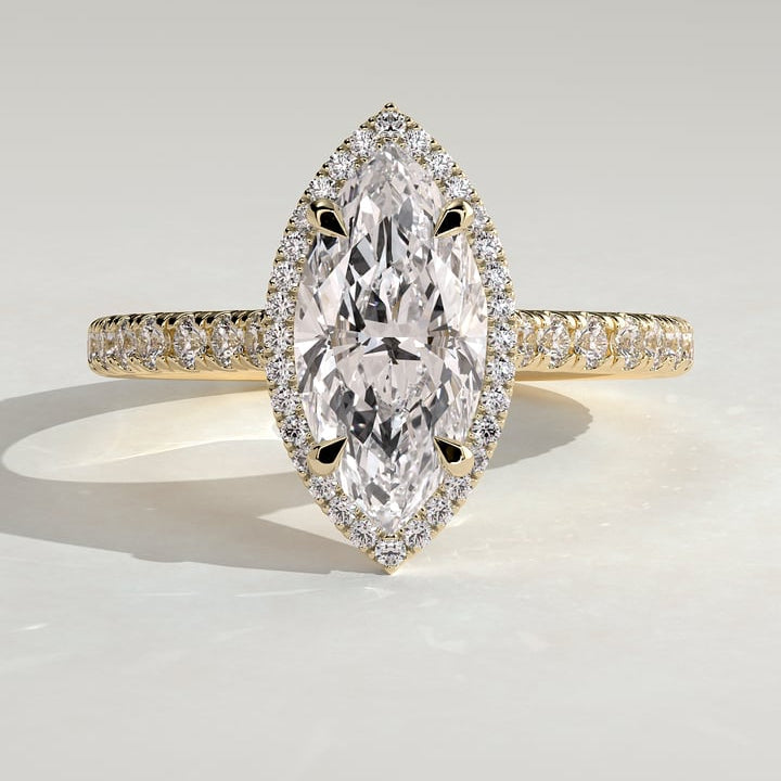 Marquise cut moissanite halo engagement ring on a pave yellow gold band