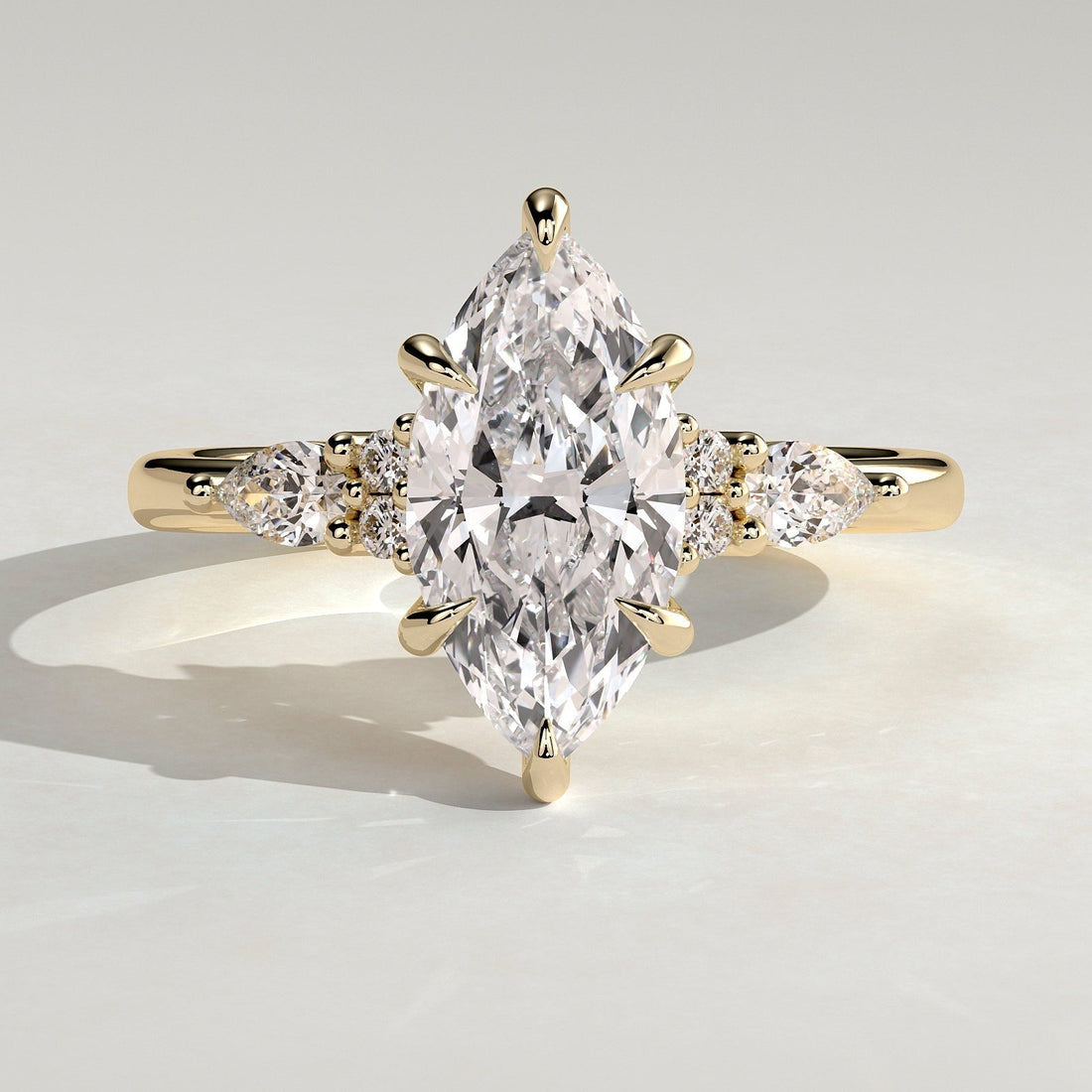 Marquise moissanite engagement ring with pear and round cluster shoulders in yellow gold